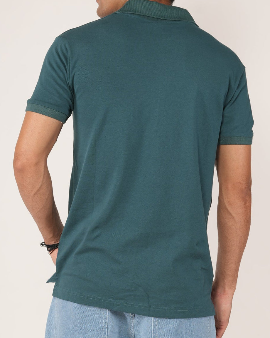 Man wearing a Teal polo T-shirt and light blue jeans.