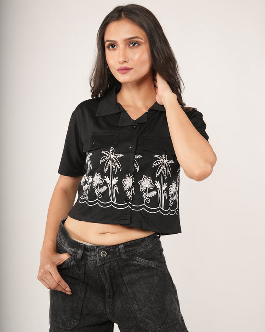 Women wearing a black printed top with washed black jeans.