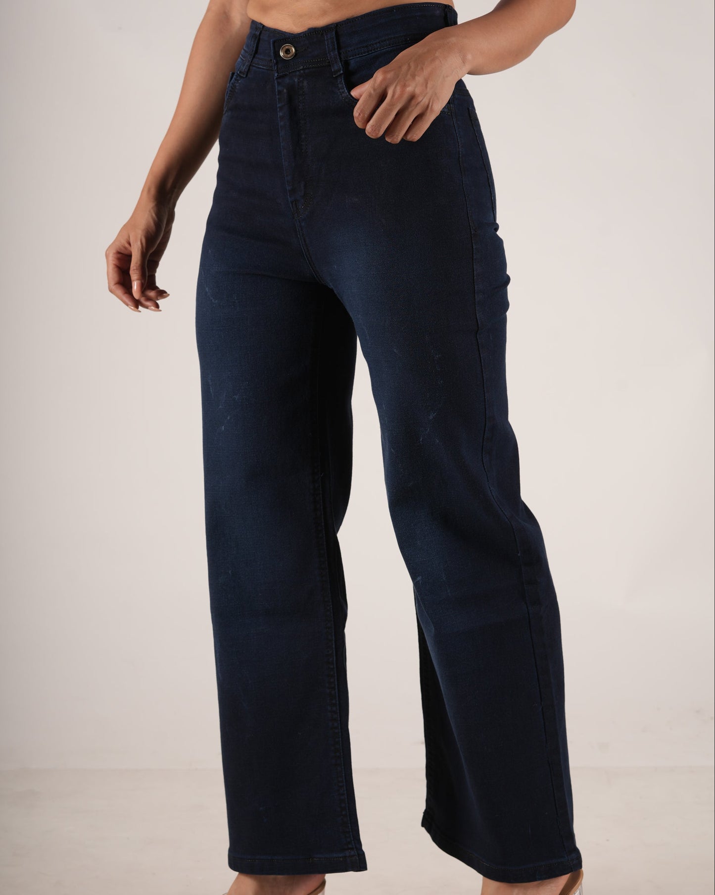 A model wearing dark navy blue high-waisted wide-leg jeans, paired with a light purple cropped top.