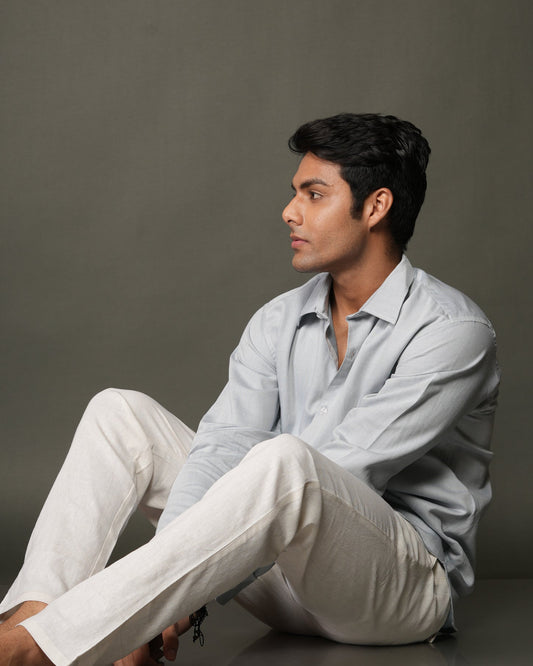 Man wearing a ice blue shirt and white pants.