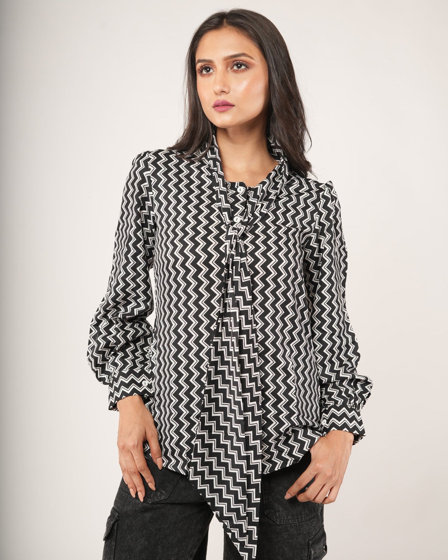 Woman wearing a black and white patterned shirt.