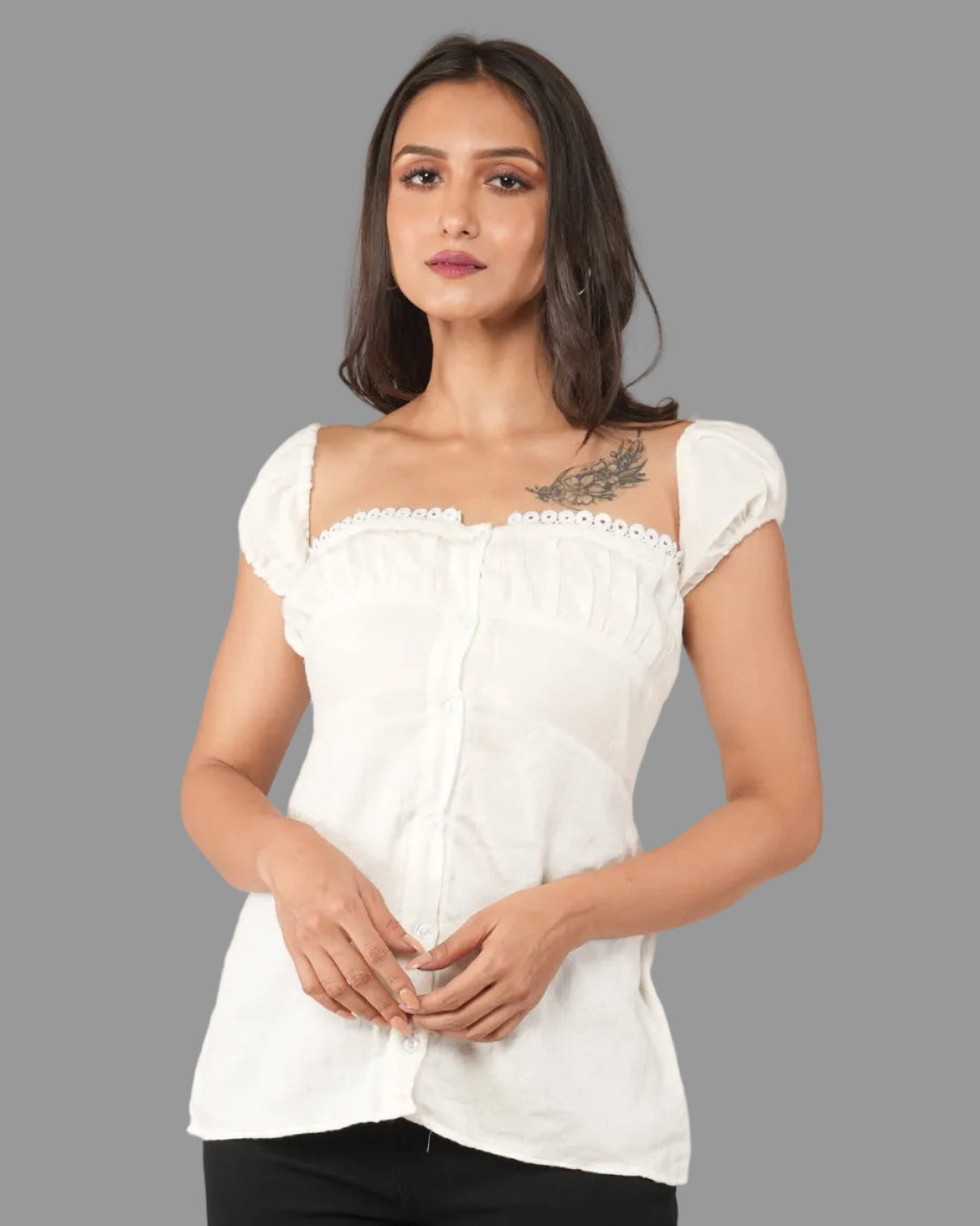 A woman modelling a white off-the-shoulder top with black wide-leg cropped pants.