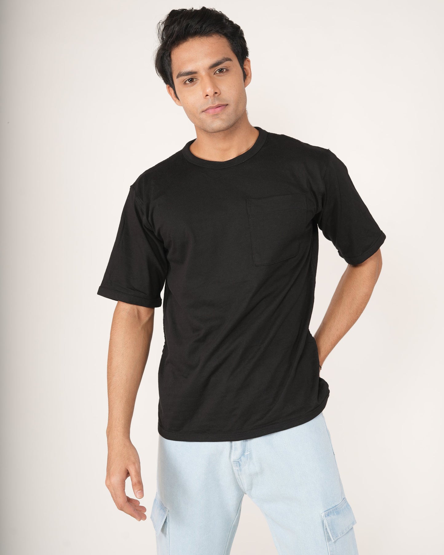 Model wearing onyx black oversized crew neck t-shirt with chest pocket and dropped shoulders
