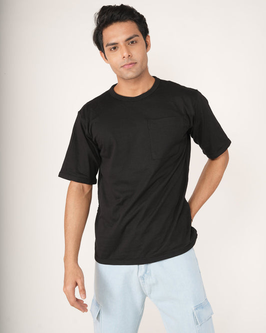 Model wearing onyx black oversized crew neck t-shirt with chest pocket and dropped shoulders