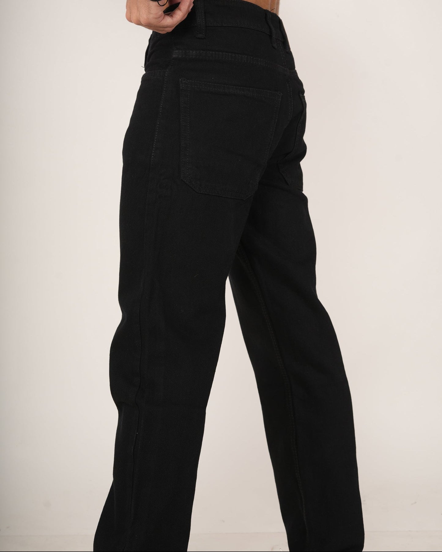Black relaxed fit jeans worn by a person.