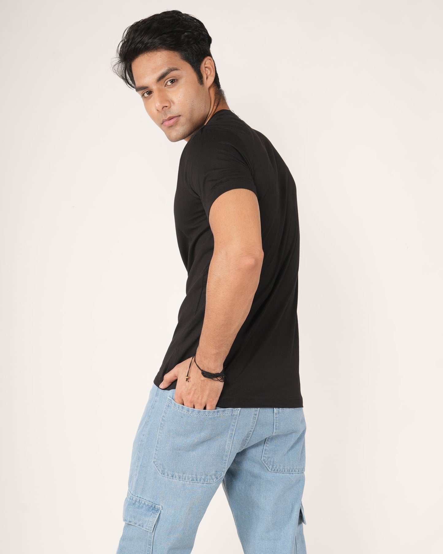 Man wearing a black t-shirt and light blue jeans.