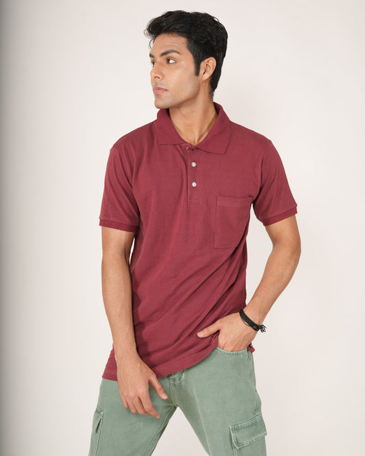 Man wearing a maroon polo shirt and light green pants against a plain background