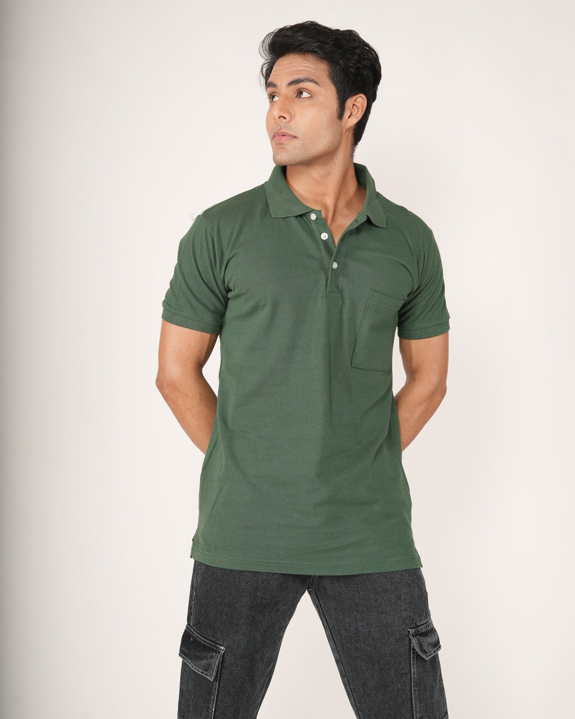Man wearing a green polo shirt and dark pants on a white background