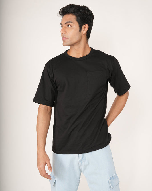 Man wearing a black t-shirt and light blue jeans on a white background