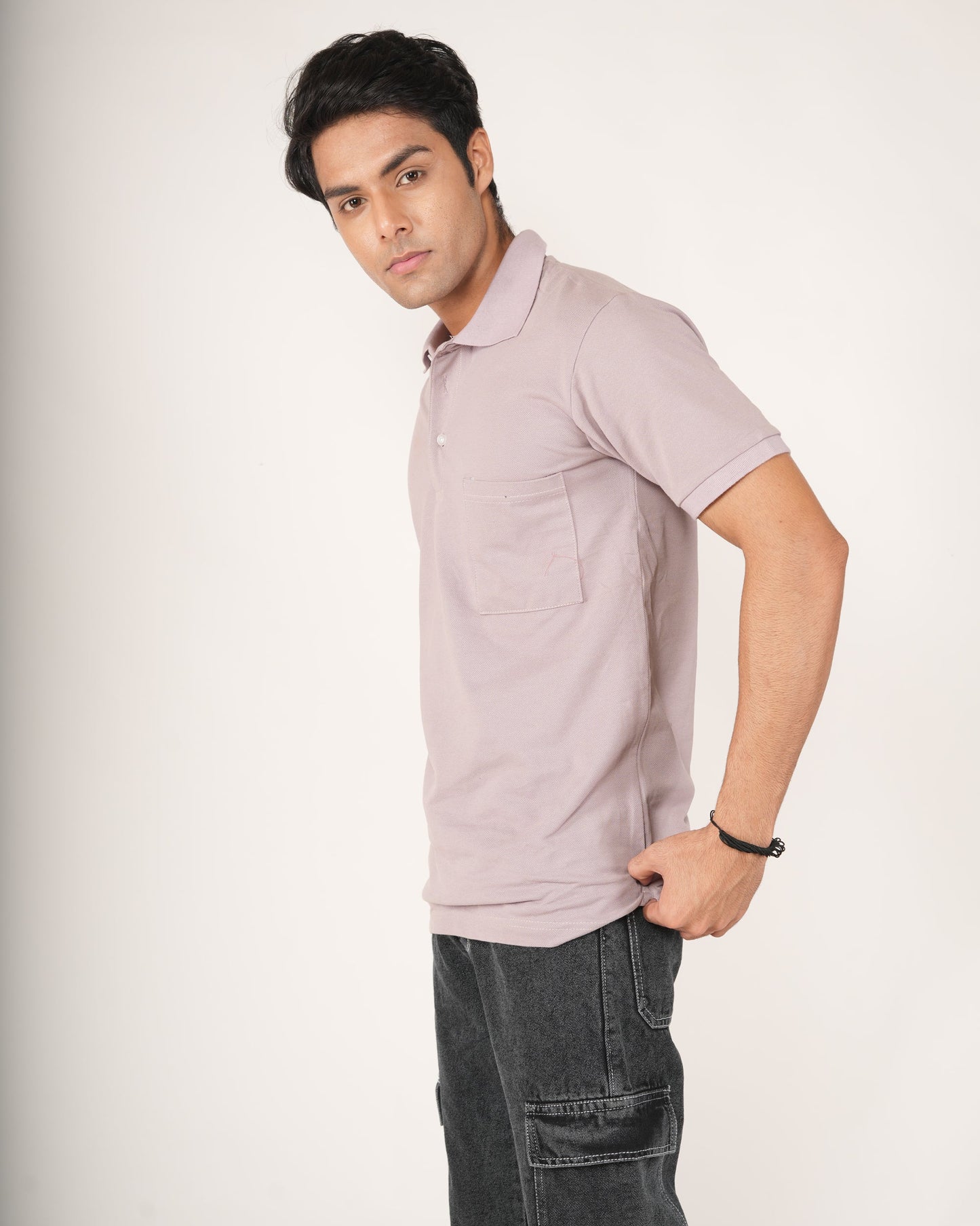 Man wearing a light purple polo shirt and dark jeans.