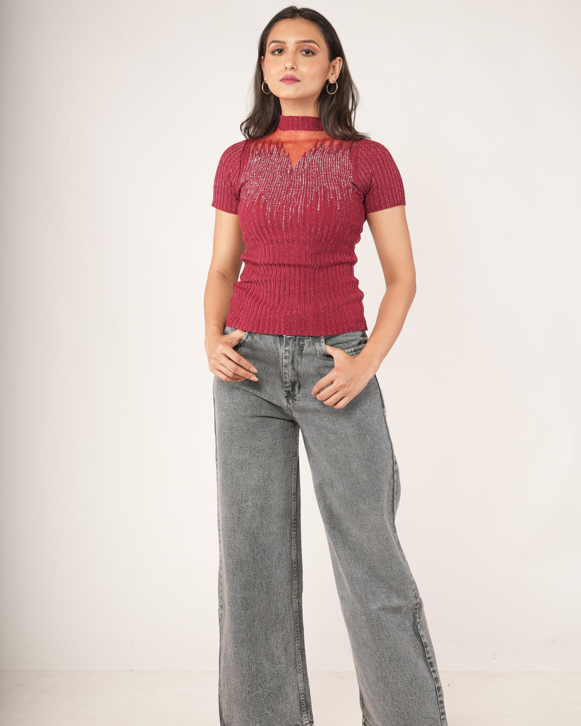 A woman modeling a Short-sleeve Fiesta Red Sheer Mesh Yoke Rhinestone Ribbed Top, paired with gray jeans.