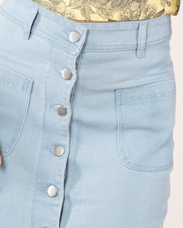 A woman modeling a light blue denim midi skirt with a front button closure.
