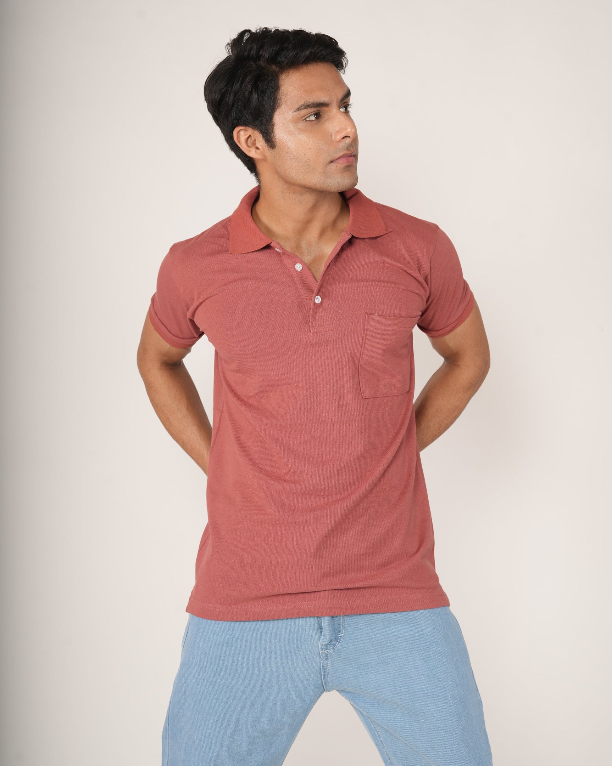 Man wearing a Rust-Red Polo T-shirt and light blue jeans.