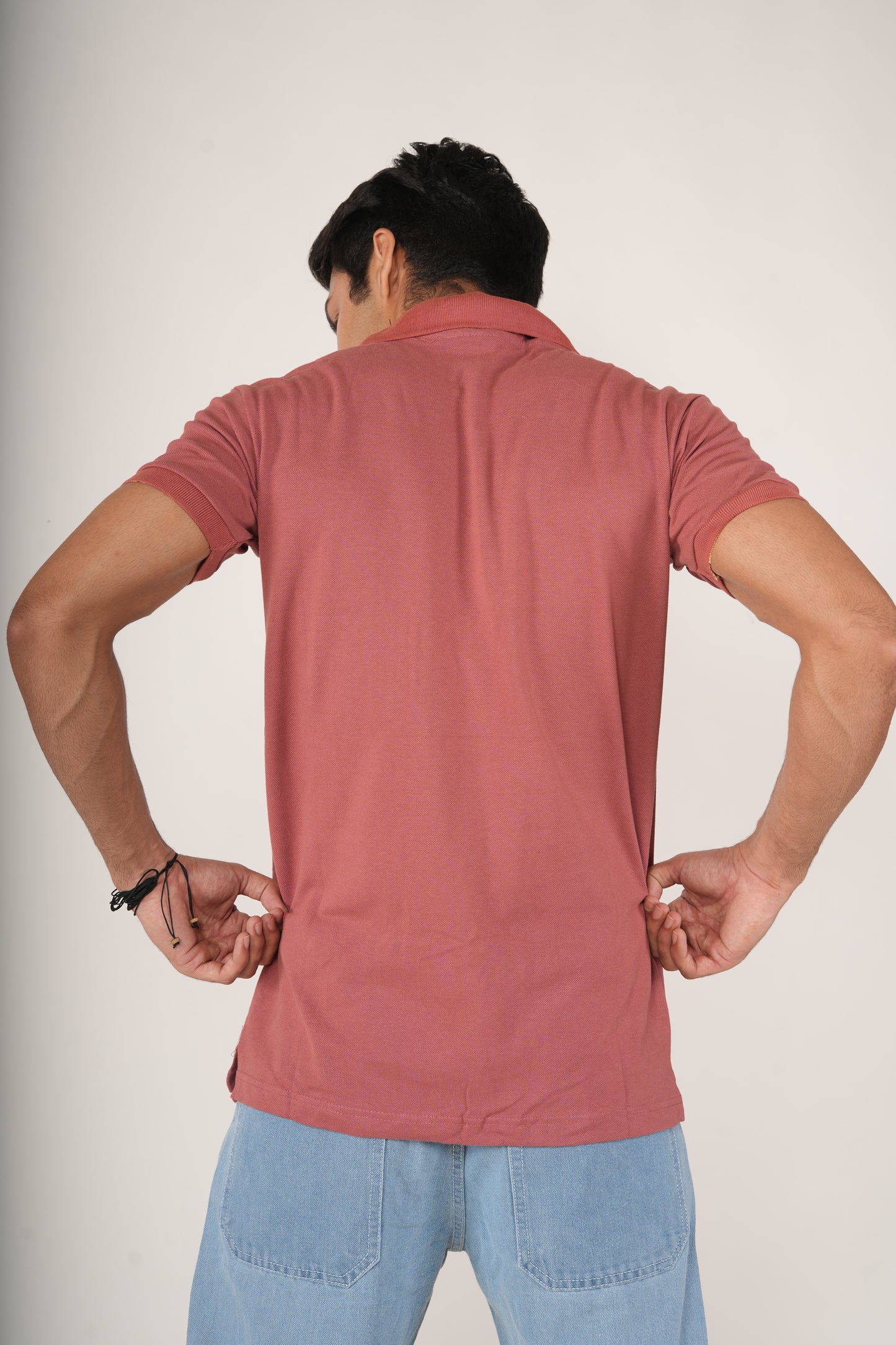 Men wearing a Rust-Red Polo T-shirt and light blue Jeans.