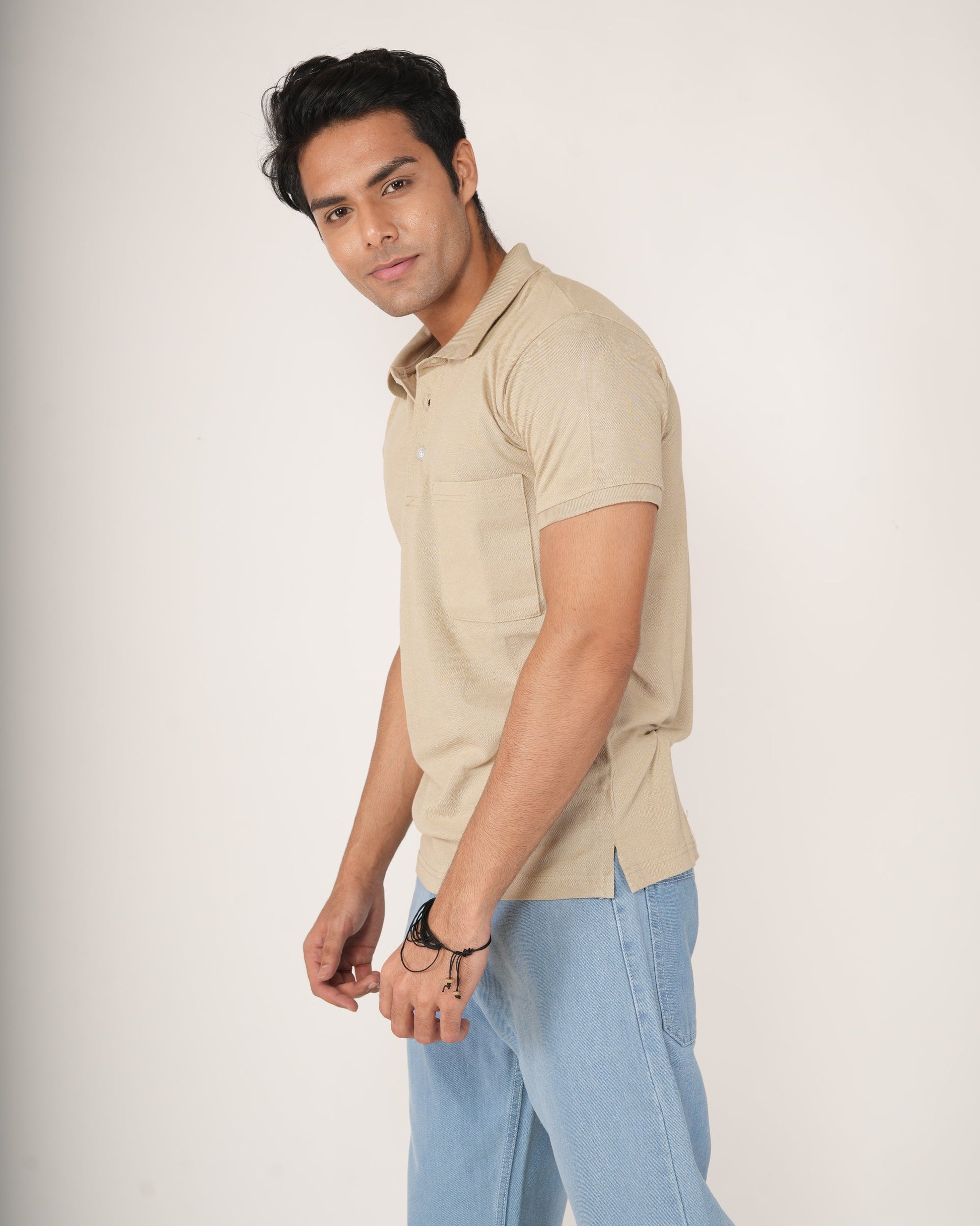 Man wearing Sand/beige polo shirt and light blue jeans.