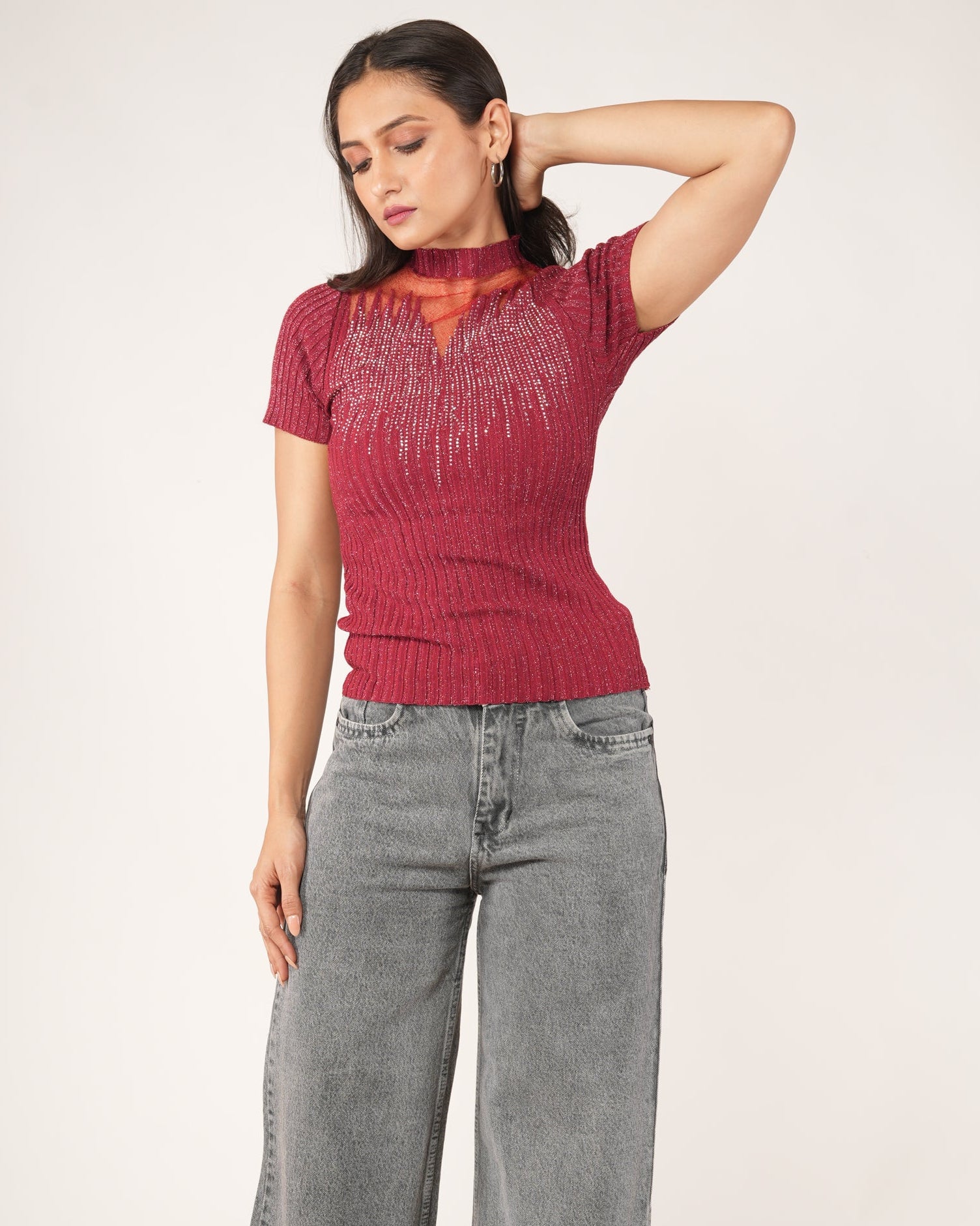 A woman modeling a Short-sleeve Fiesta Red Sheer Mesh Yoke Rhinestone Ribbed Top, paired with gray jeans.