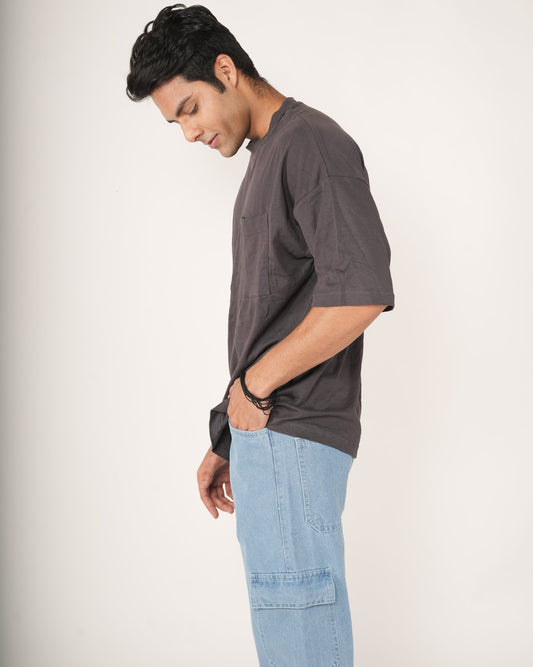 Man wearing a slate gray t-shirt and light blue jeans.