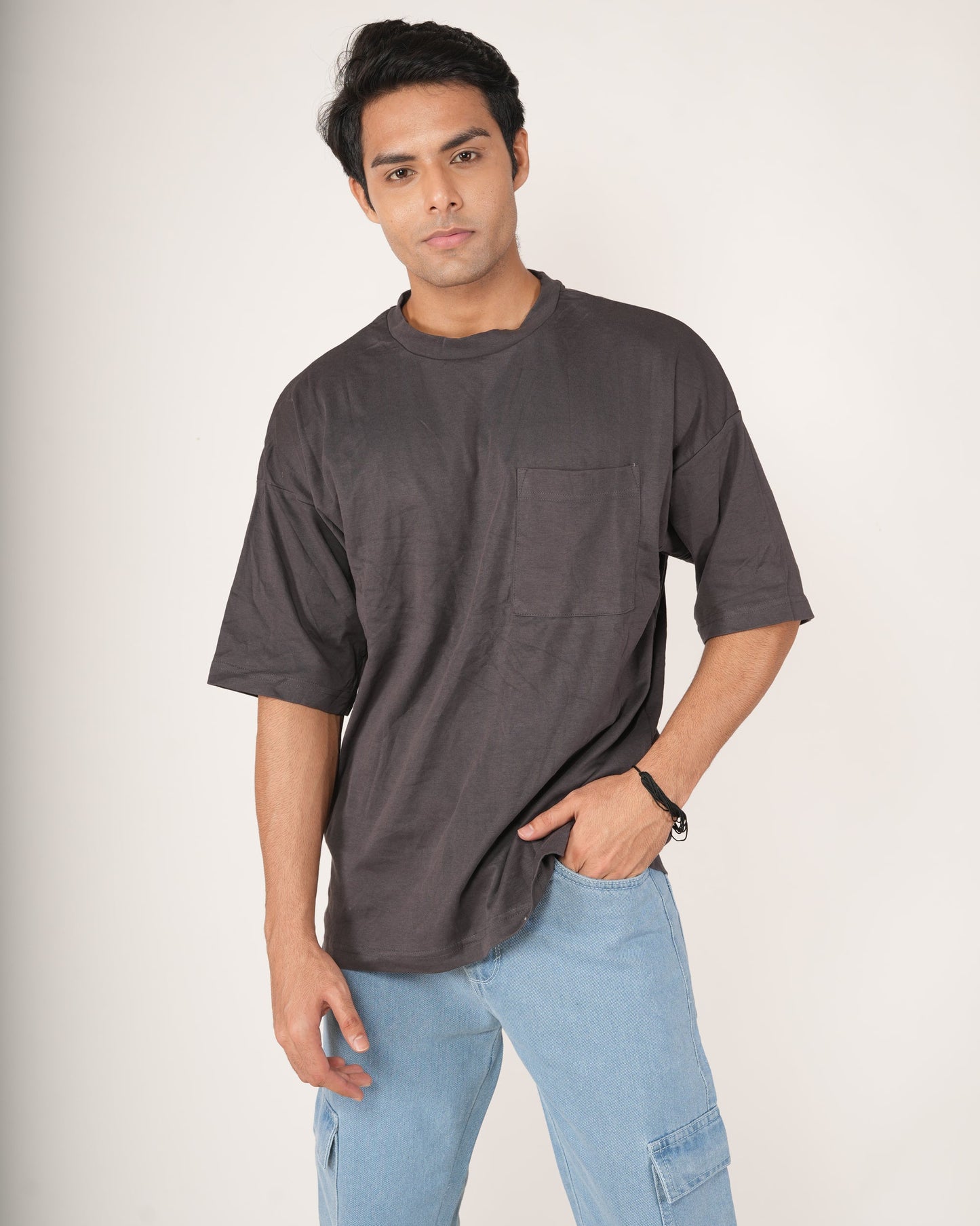 Man wearing a slate gray t-shirt and light blue jeans.