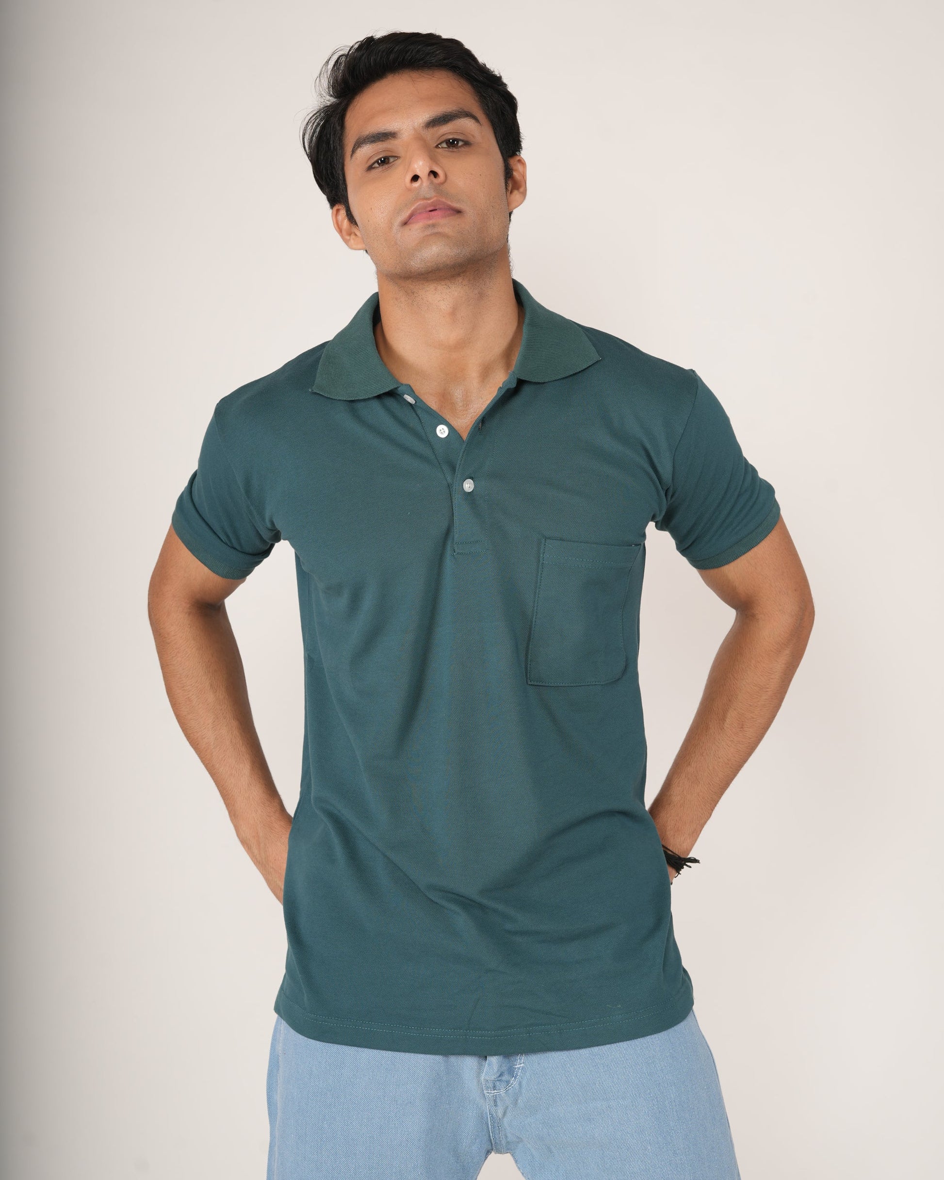 Man wearing a teal polo shirt and light blue jeans.