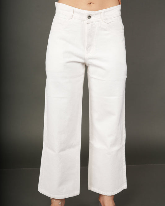 White cropped wide-leg jeans worn by a model, paired with a peach top and clear high-heeled sandals.