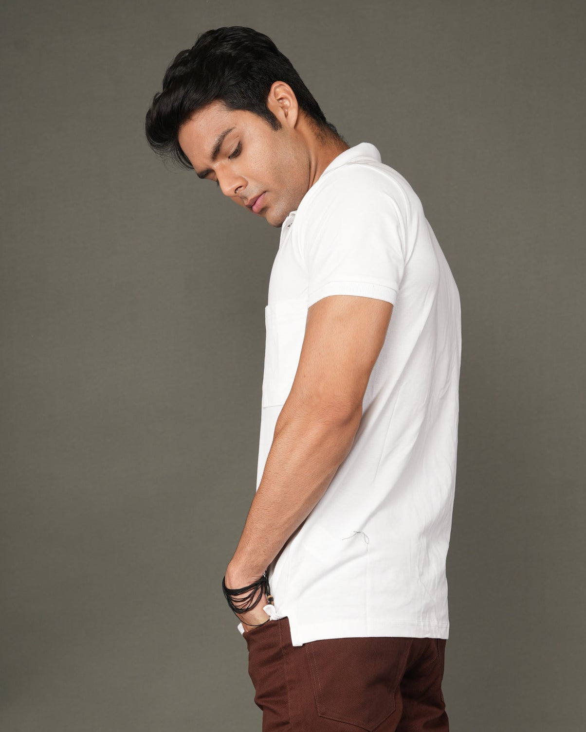 Man wearing a white polo t-shirt and brown cargo pants.
