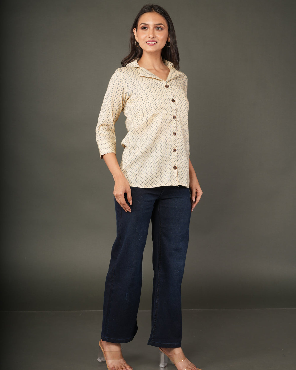 A woman modeling a beige and white zigzag patterned button-up shirt with dark brown buttons