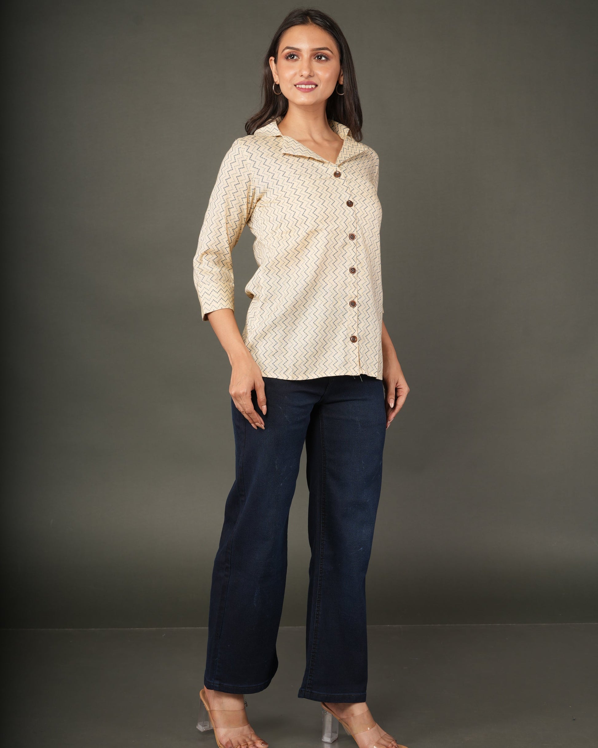 A woman modeling a beige and white zigzag patterned button-up shirt with dark brown buttons