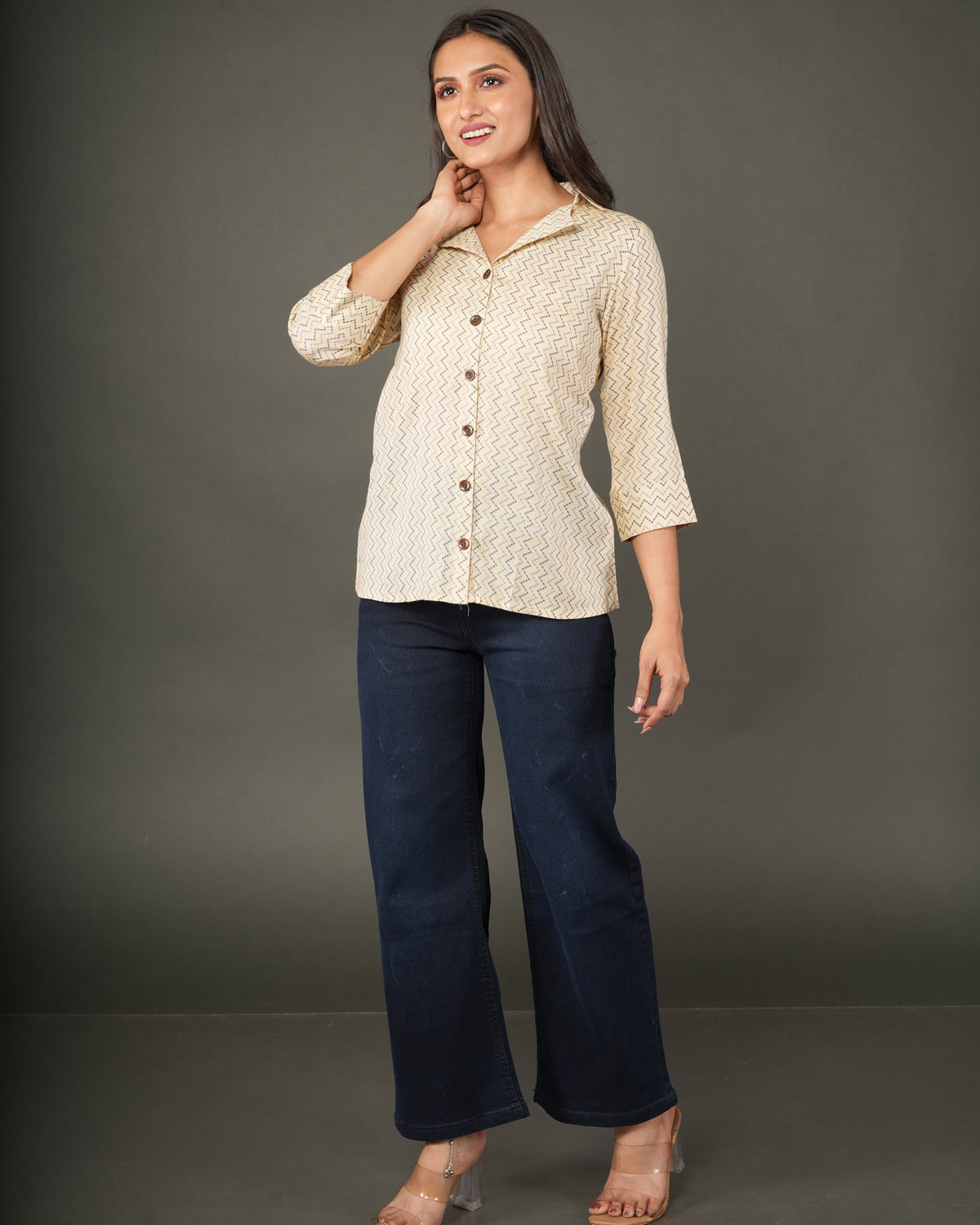 A woman modeling a beige and white zigzag patterned button-up shirt with dark brown buttons