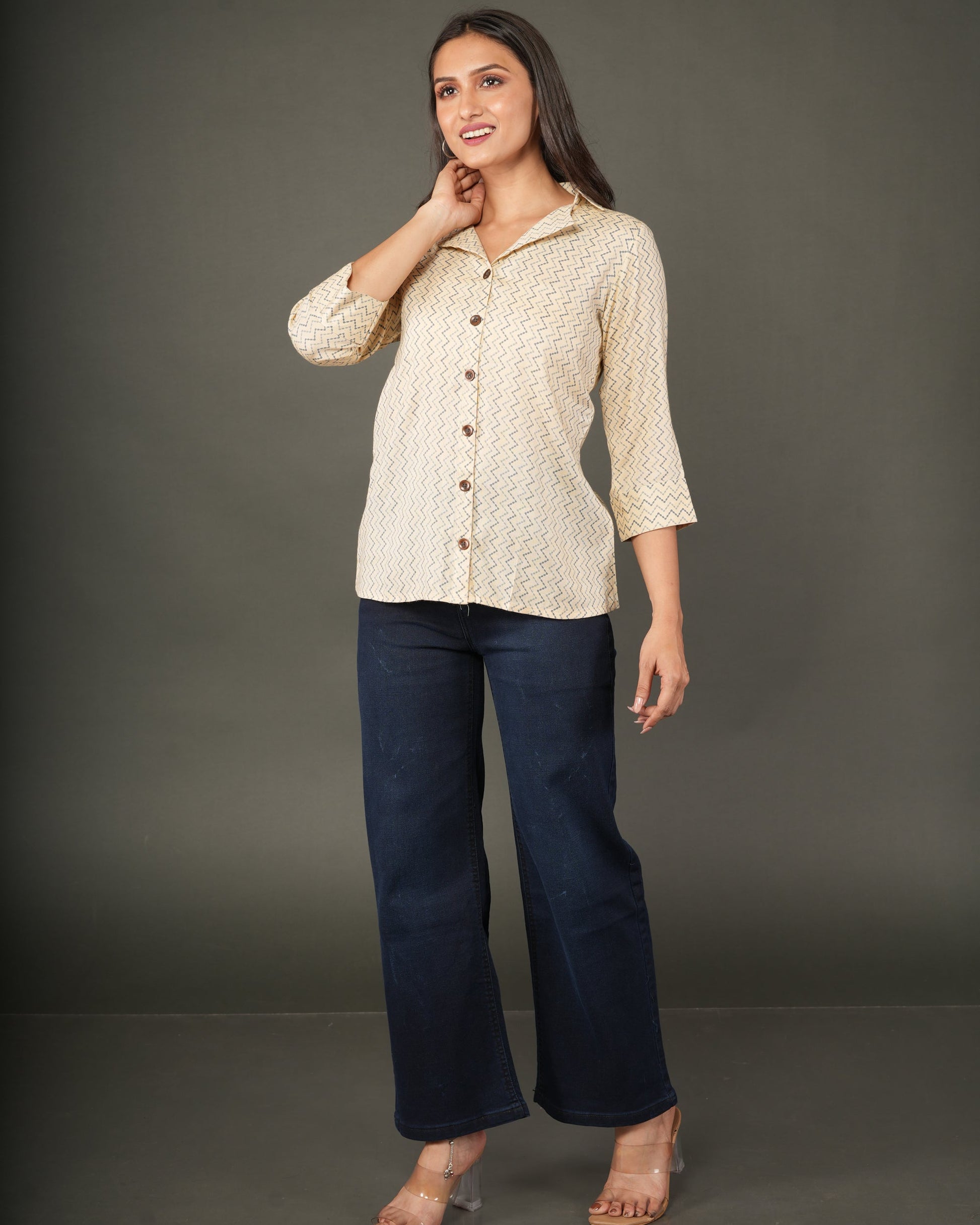 A woman modeling a beige and white zigzag patterned button-up shirt with dark brown buttons
