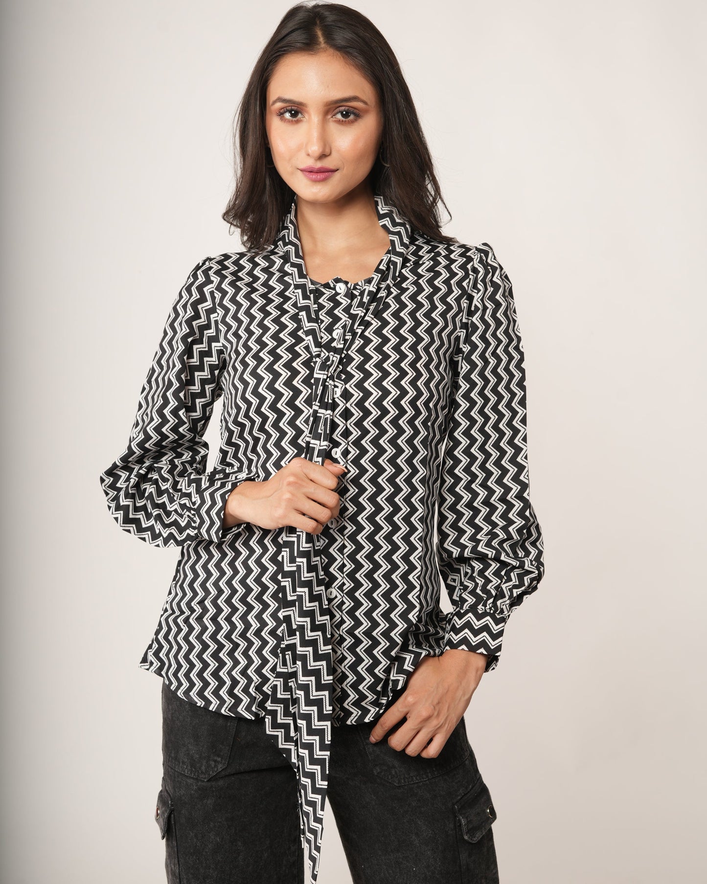 Woman wearing a black and white patterned shirt.