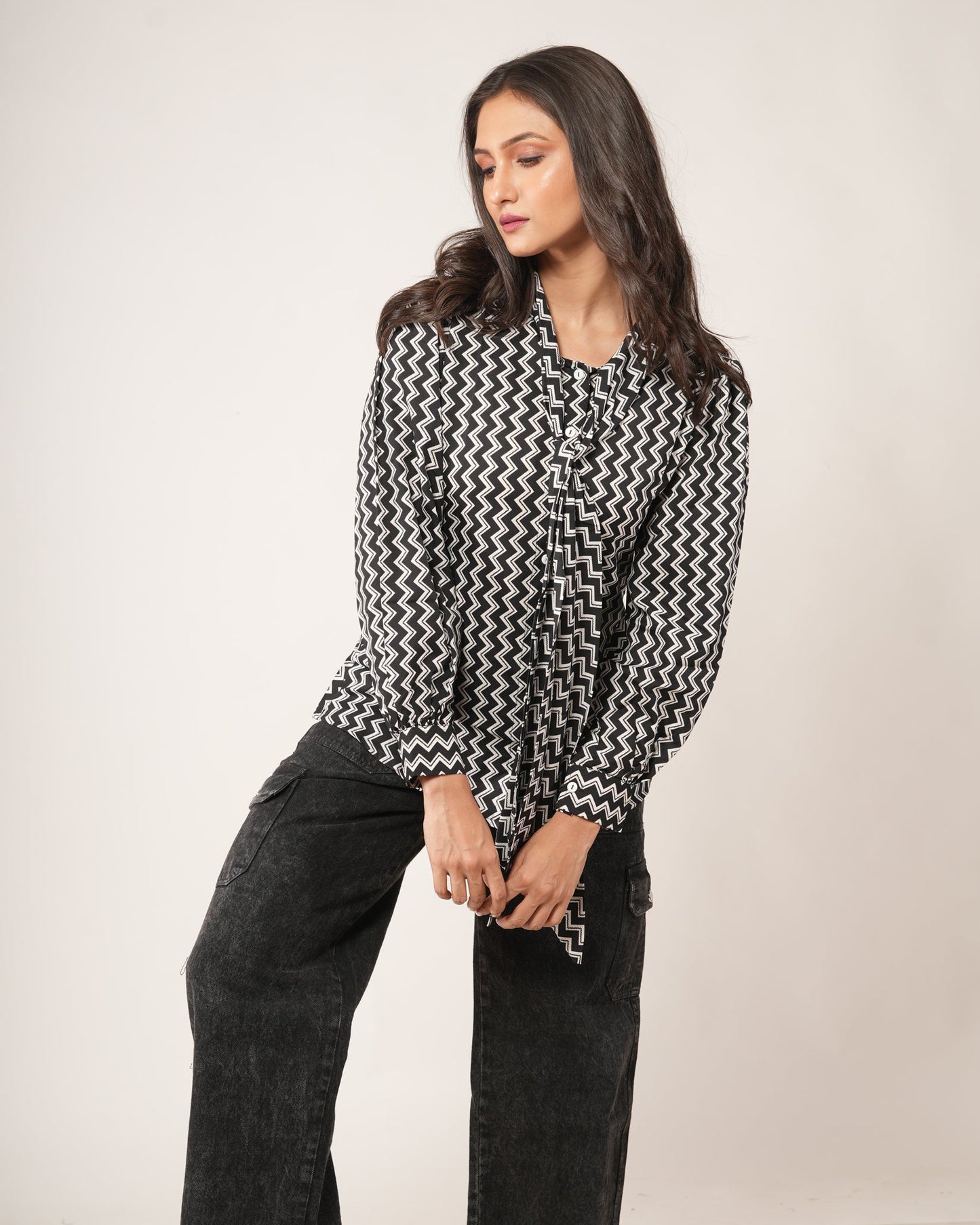 Woman wearing a black and white patterned shirt.