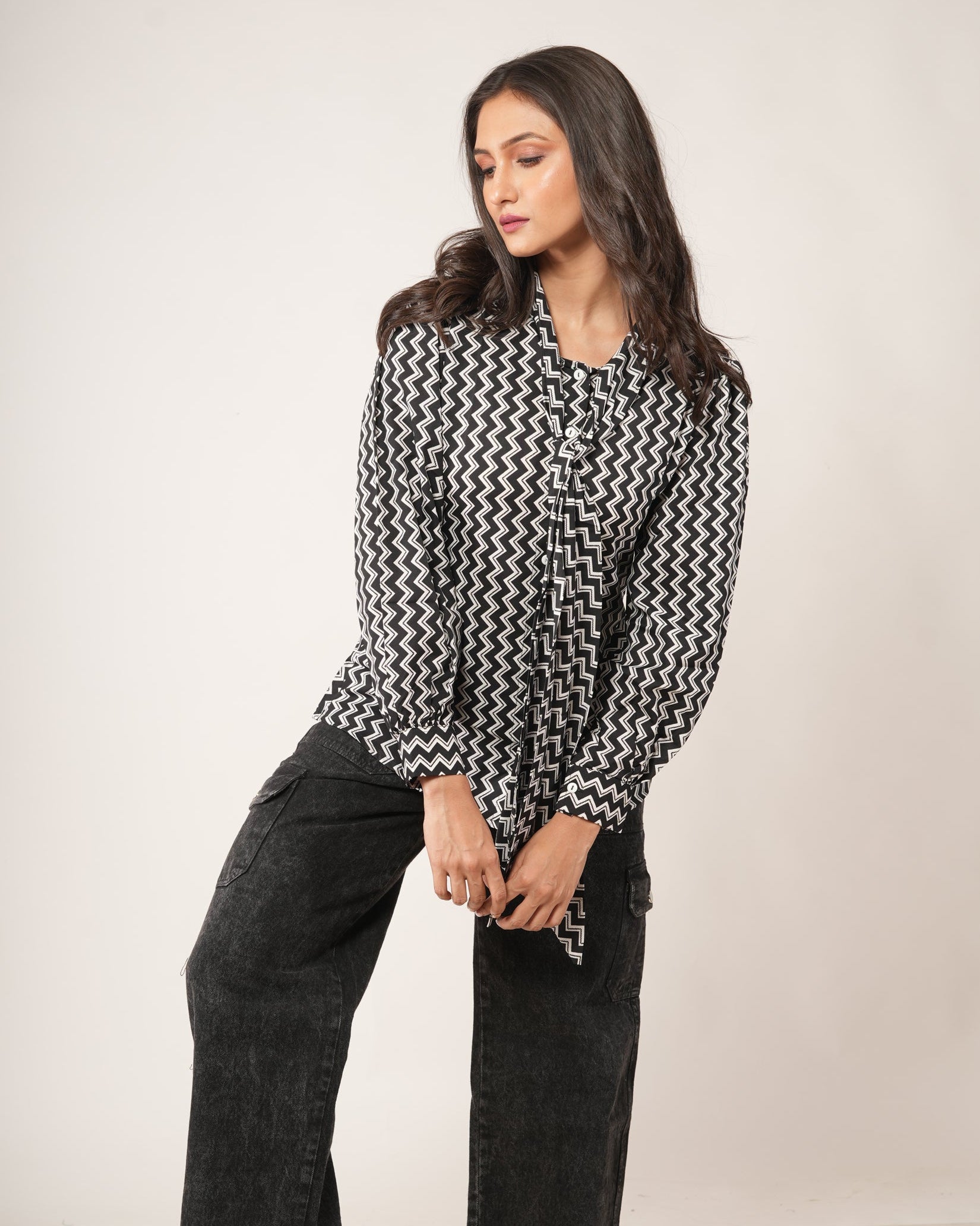 Woman wearing a black and white patterned shirt.