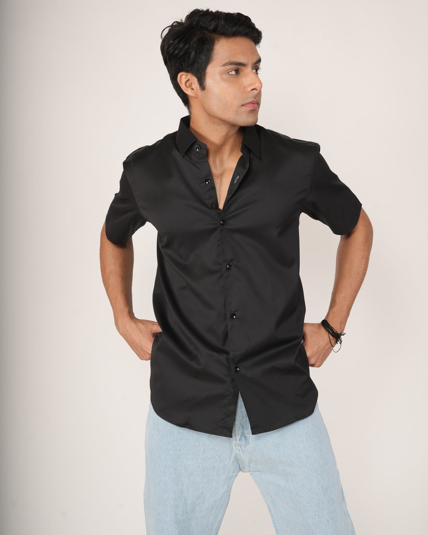 Man wearing a black half-sleeve shirt and light blue jeans.