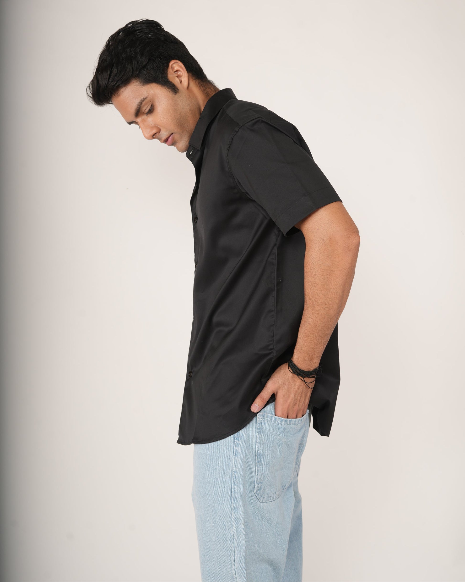 Man wearing a black half-sleeve shirt and light blue jeans.