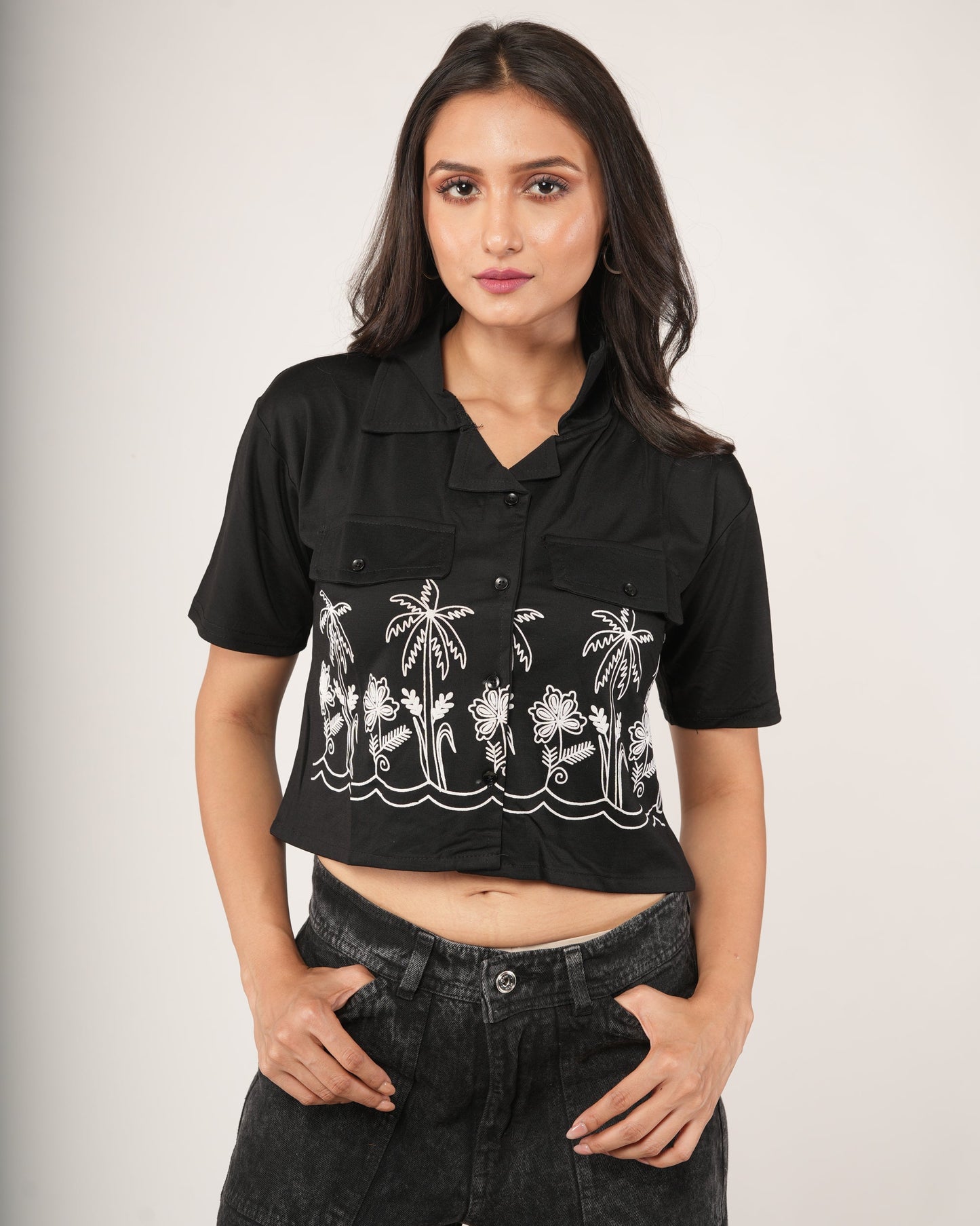 Woman wearing a black printed top and black pants.