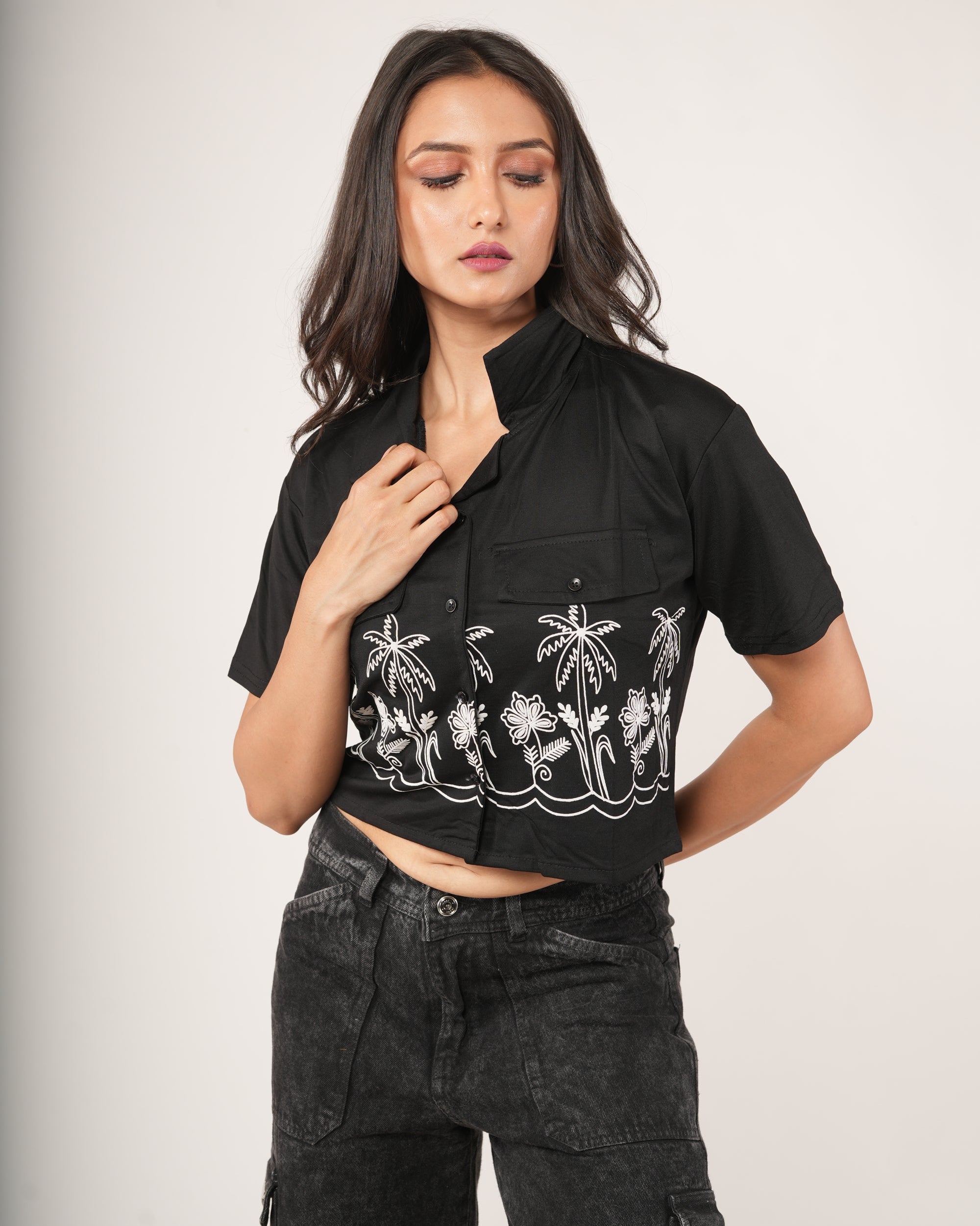 Woman wearing a black printed top and black pants.