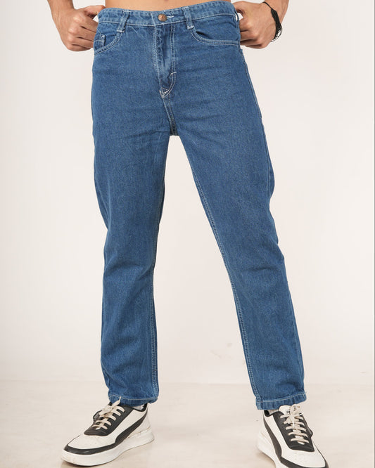 Man wearing blue jeans and black and white sneakers.