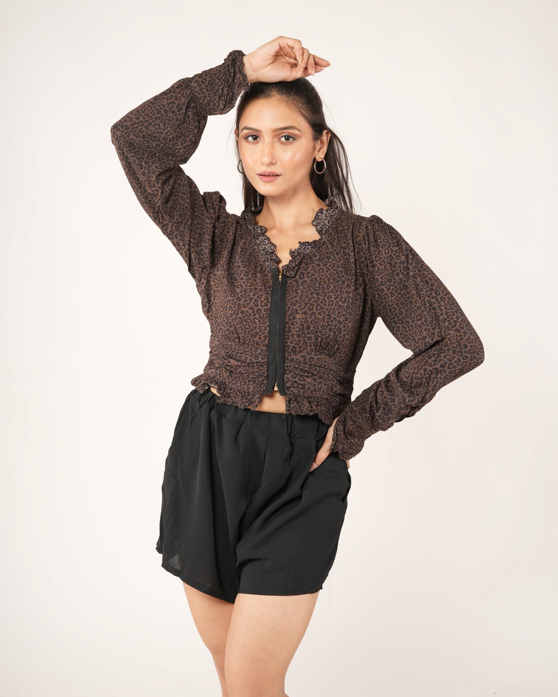 A woman modeling a brown leopard-print long-sleeve cropped top with a black front zipper