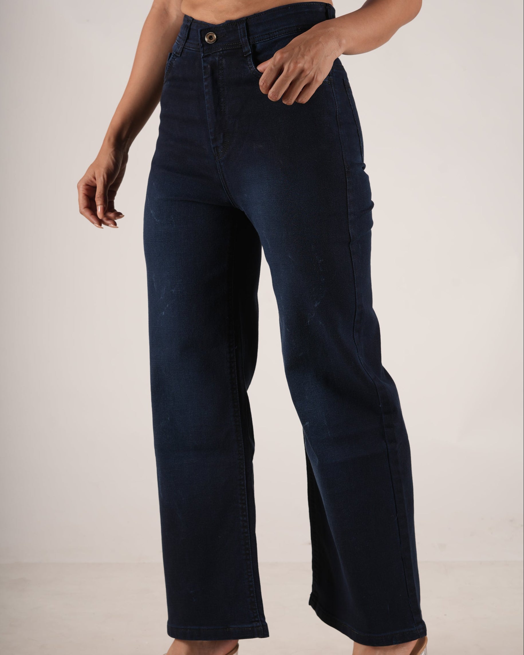 A model wearing dark navy blue high-waisted wide-leg jeans, paired with a light purple cropped top.