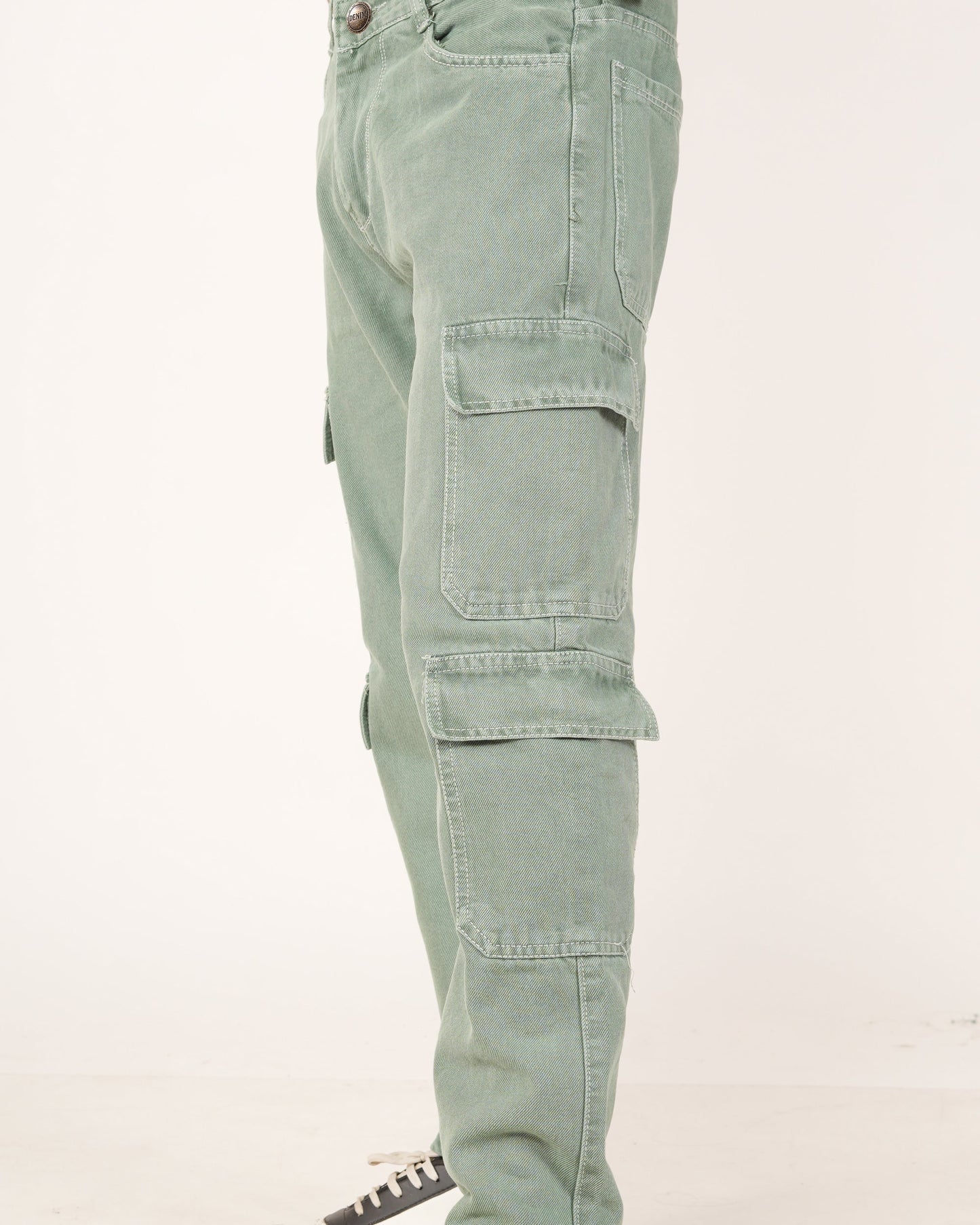 A side profile view of a person wearing sage green 8 pocket cargo jeans, showing the side pockets.