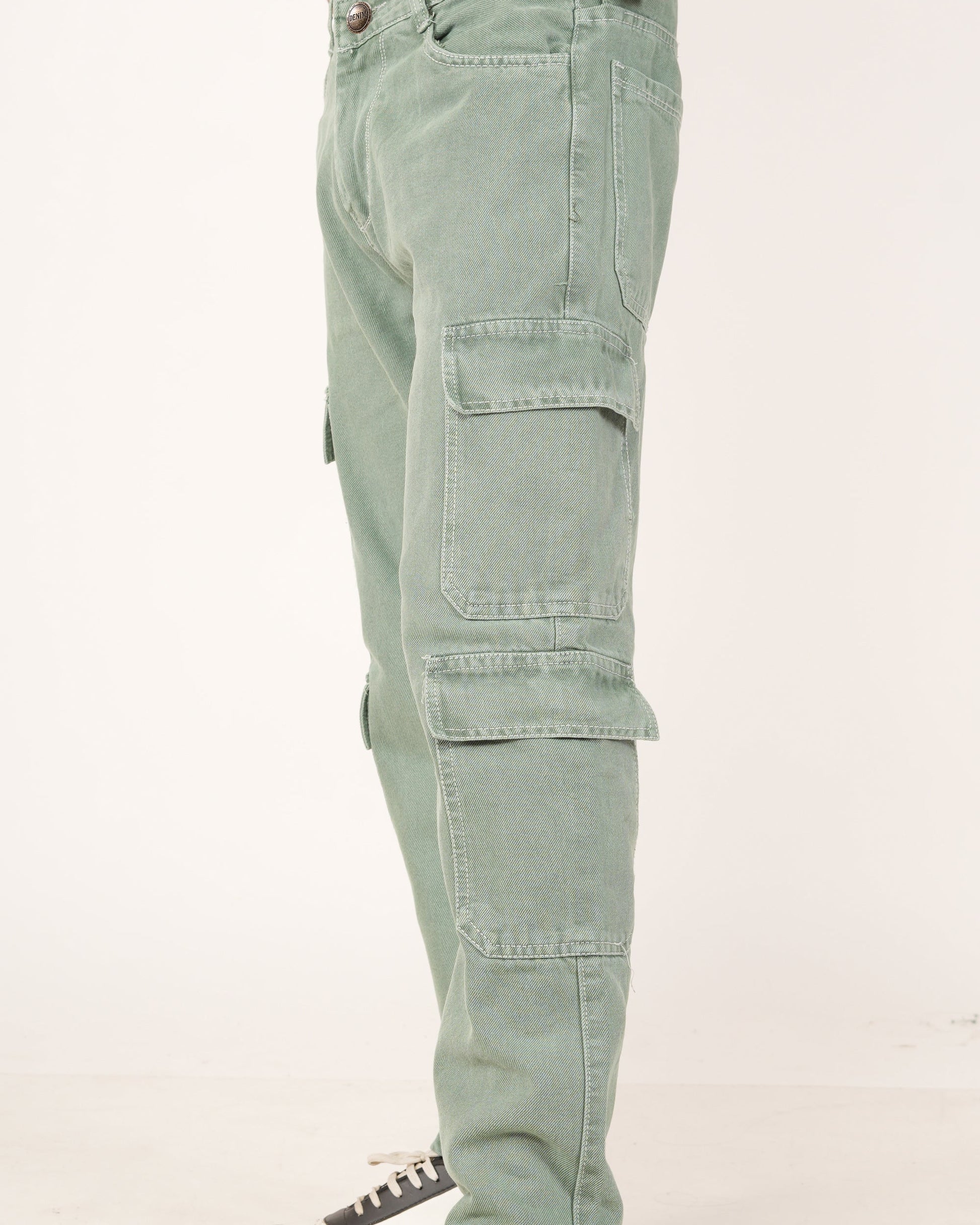 A side profile view of a person wearing sage green 8 pocket cargo jeans, showing the side pockets.