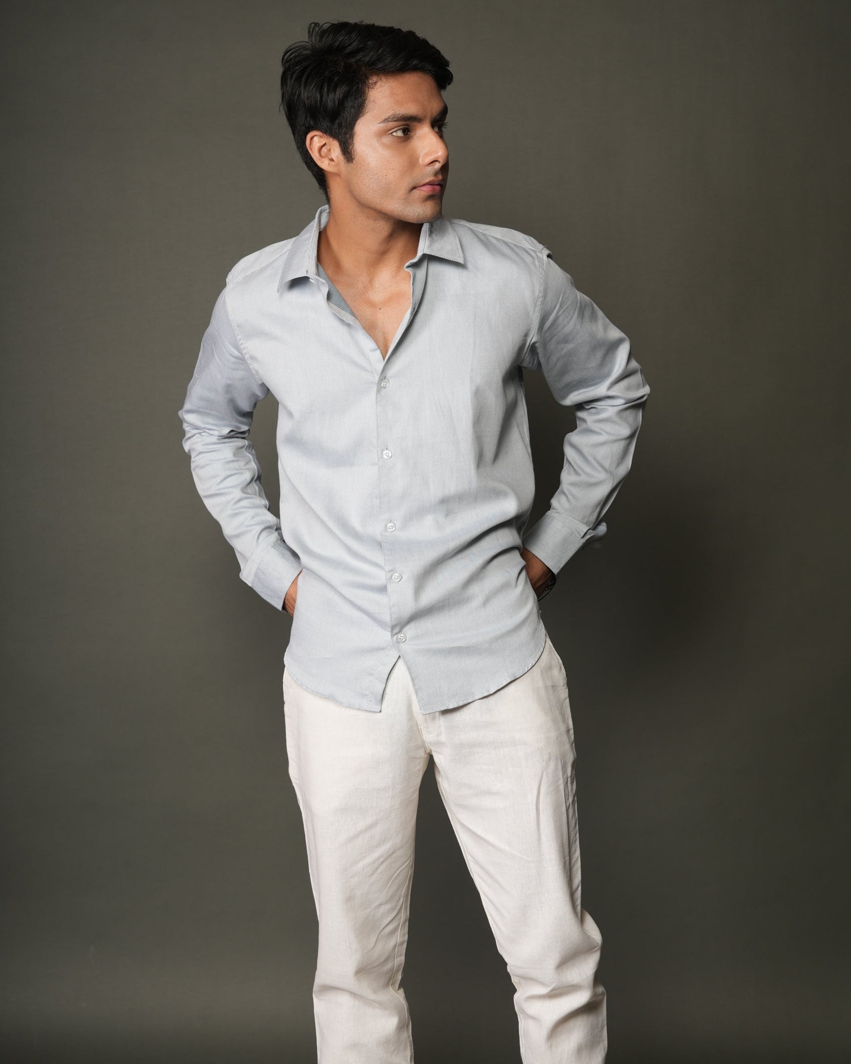 Man wearing a ice blue shirt and white pants.