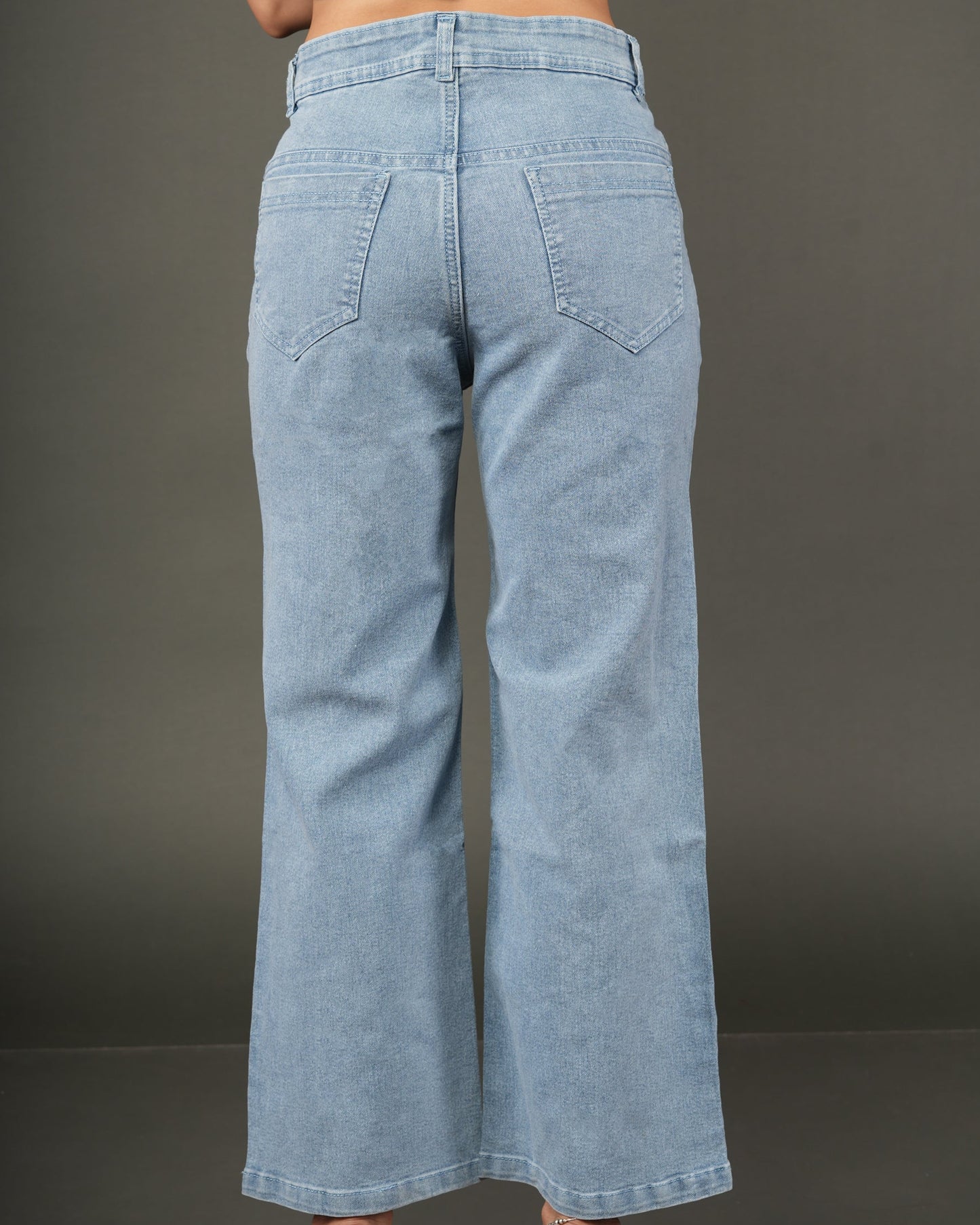 A person shown from the back wearing light-wash blue wide-leg jeans and a navy sleeveless.