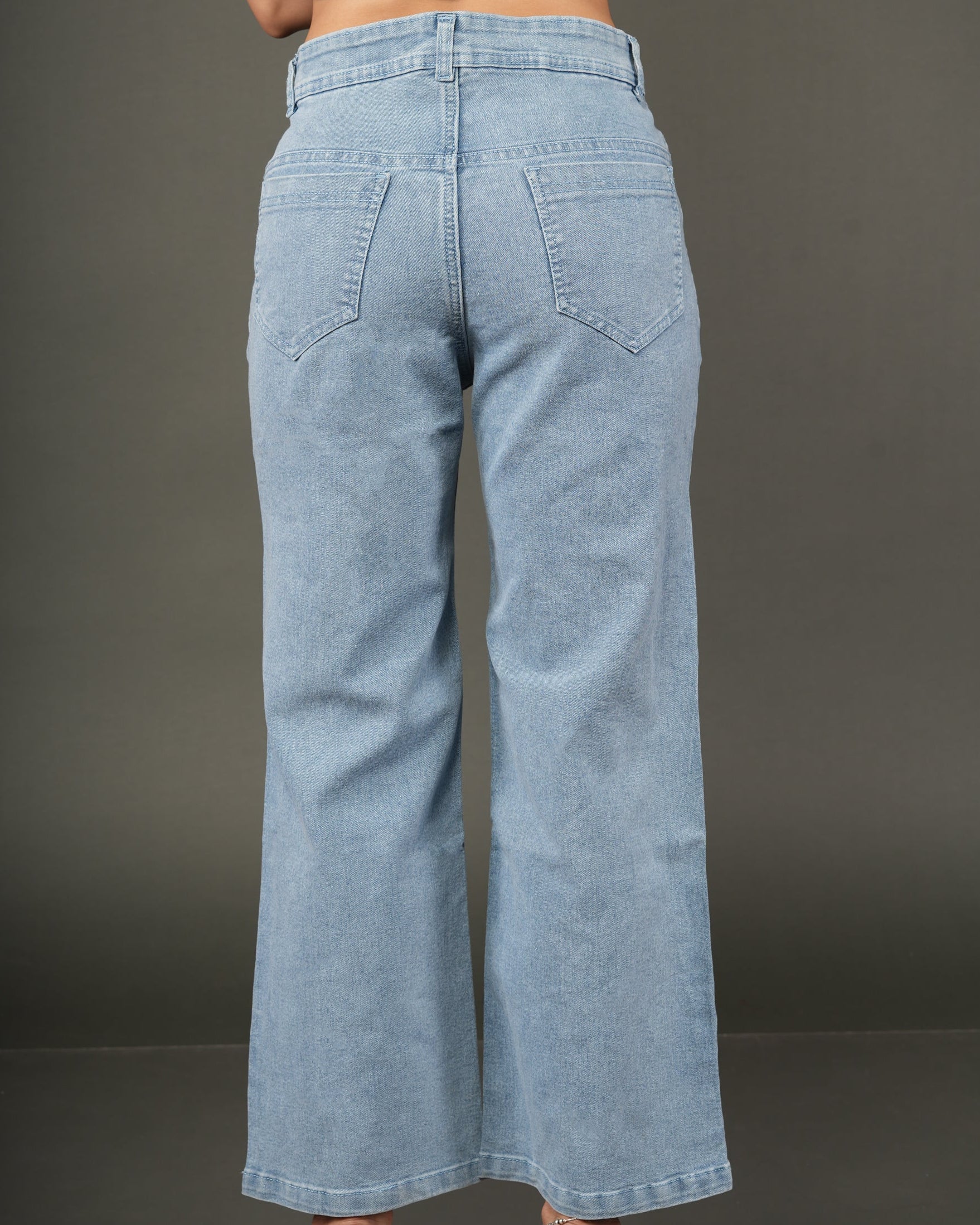 A person shown from the back wearing light-wash blue wide-leg jeans and a navy sleeveless.