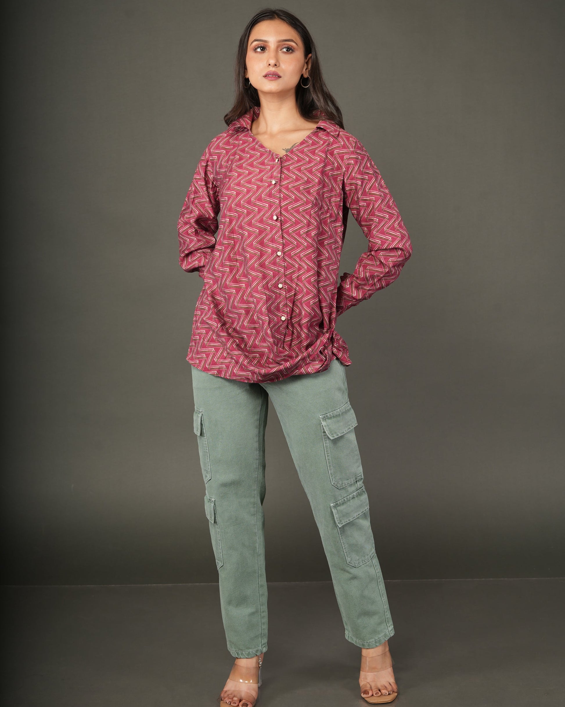 A woman modeling a long-sleeve, button-front top with a pink and red chevron pattern.