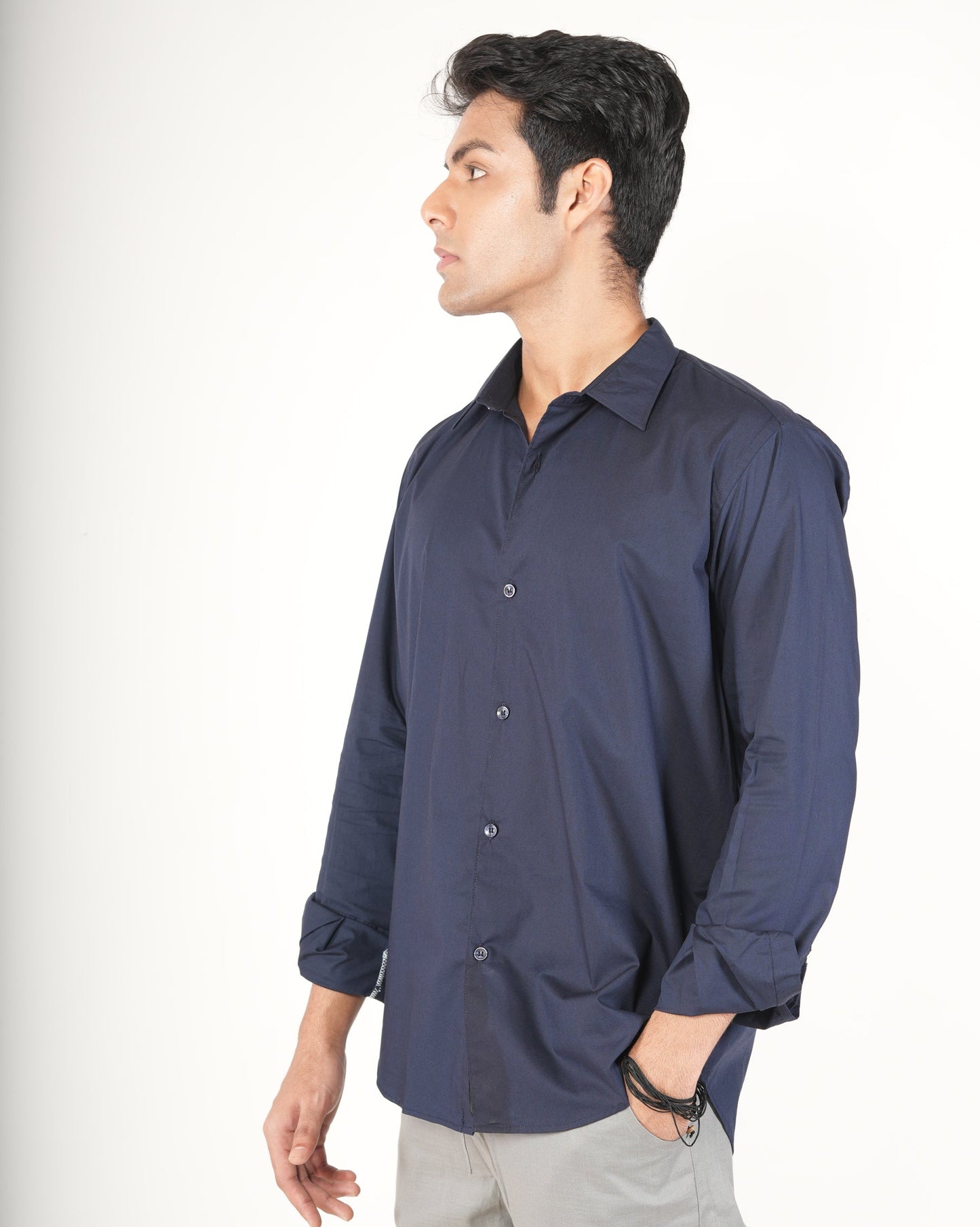 A man wearing a navy blue long-sleeve button-up shirt