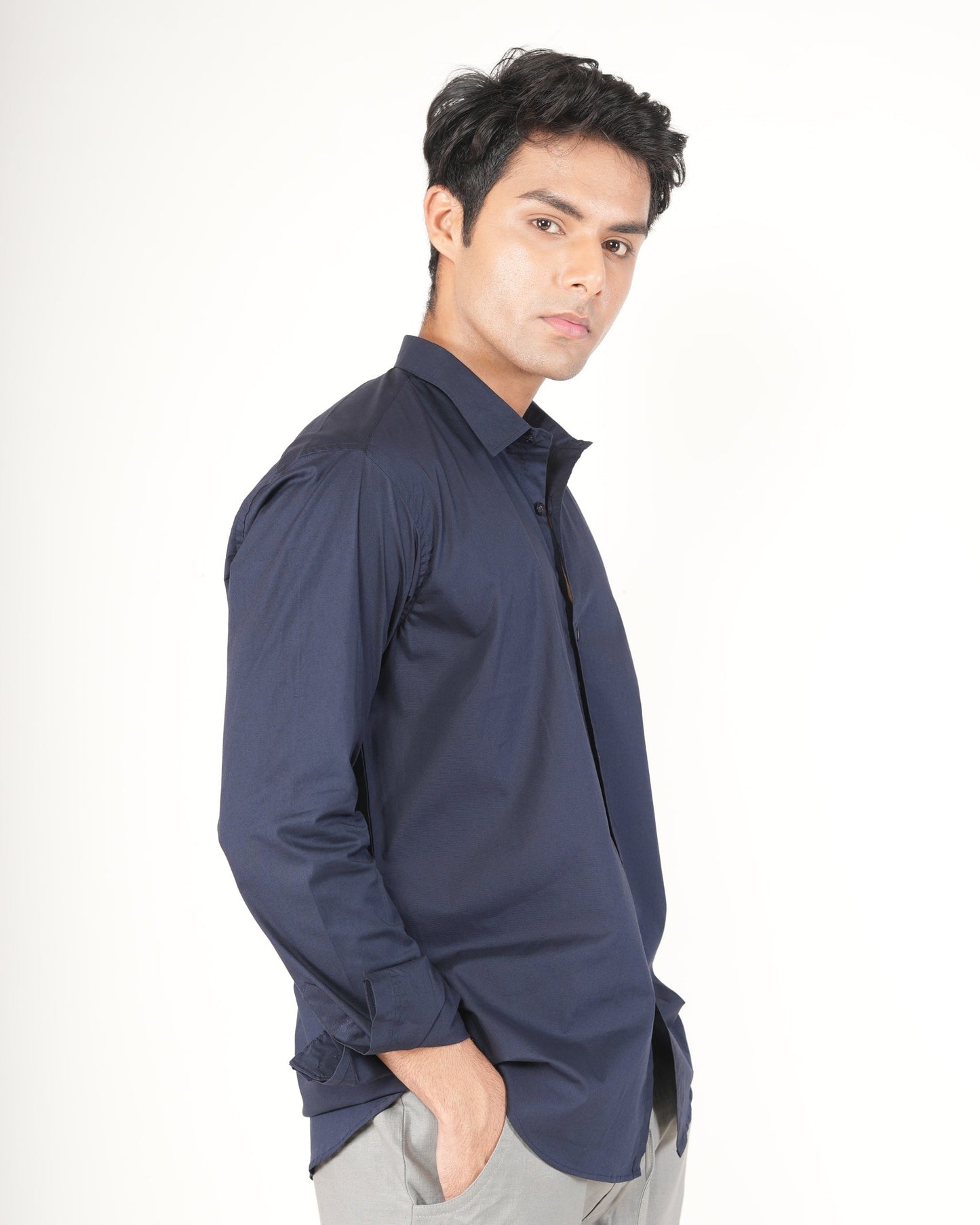 A man wearing a navy blue long-sleeve button-up shirt