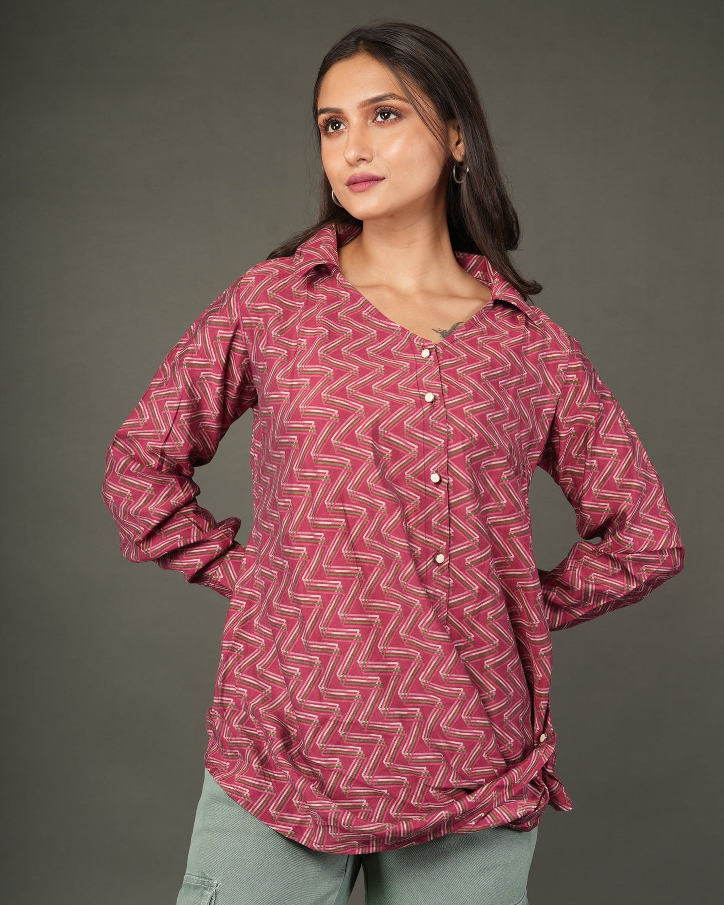 A woman modeling a long-sleeve, button-front top with a pink and red chevron pattern.