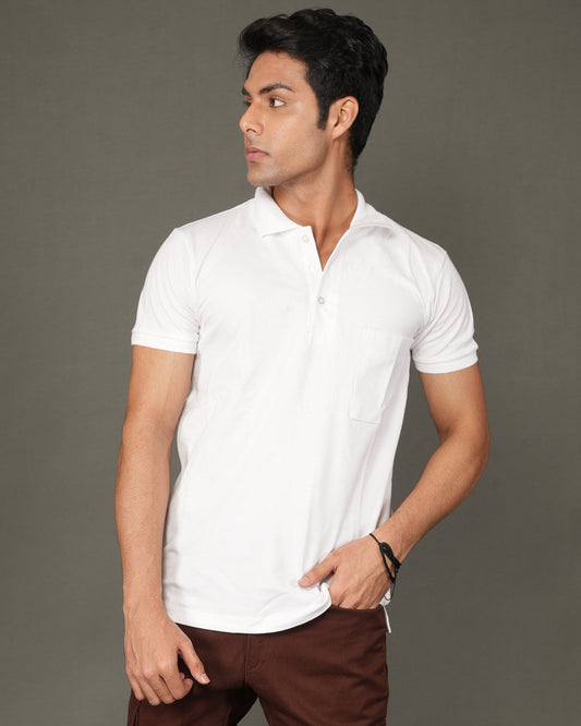 Man wearing a white polo t-shirt and brown pants against a gray background