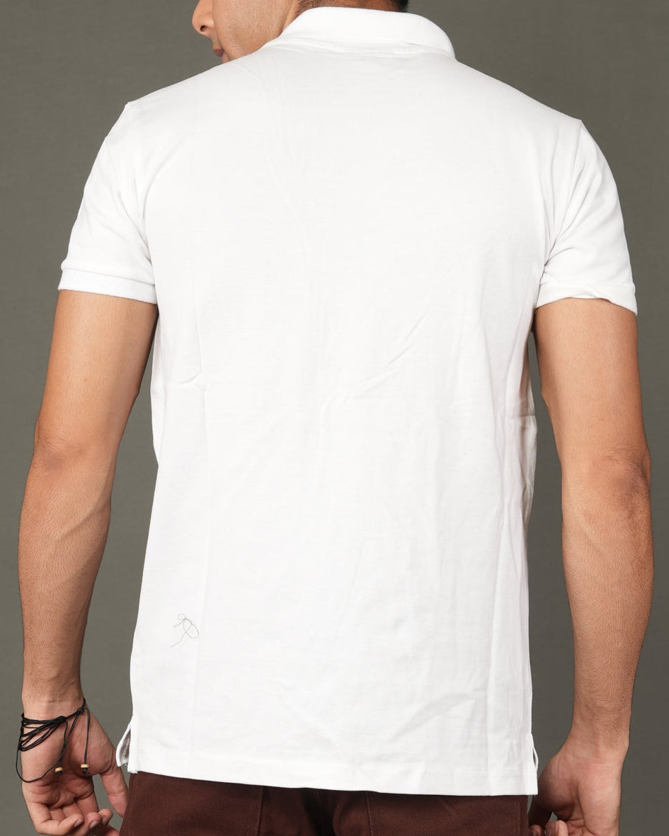 Man wearing a white polo t-shirt and brown pants.